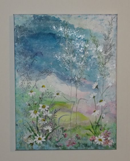 Färgglada blommor på äng med blå himmel.