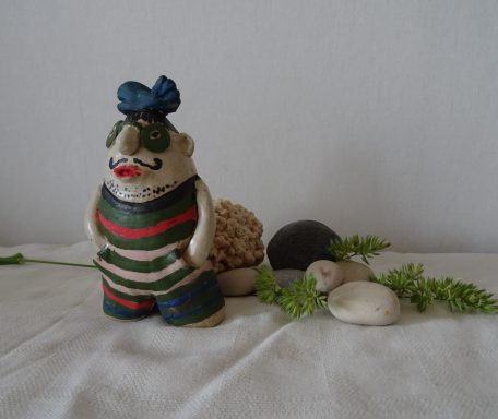 Figur i keramik med fisk på sitt huvud.